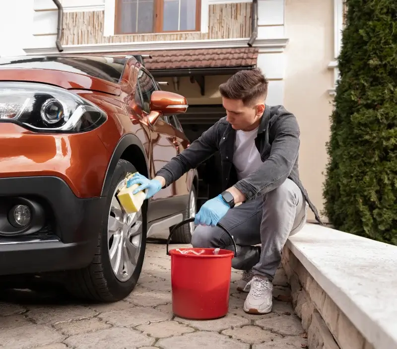 Lavage auto à domicile Saint-Ouen-de-Mimbré : professionnel intervenant sur un véhicule